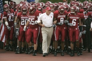 Football Coach walking with players in red uniforms