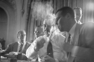 Smoke filled room with men in suits smoking cigars
