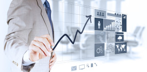 Person in suit drawing line graph with accompanying infographic next to it