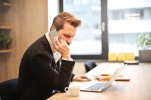 Man at Desk Speaking on Phone