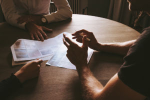 meeting between two people with papers in middle