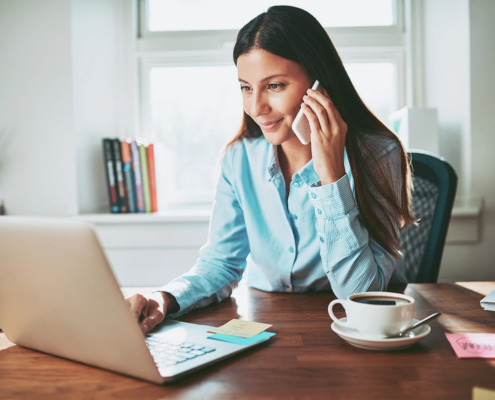 Person Talking on Phone whilst working on Laptop