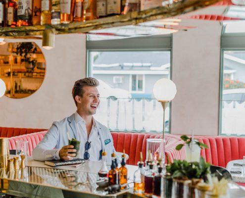 Person Celebrating with Drink at Bar