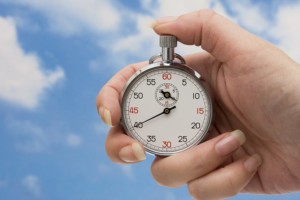 Hand on Stopwatch with sky as background