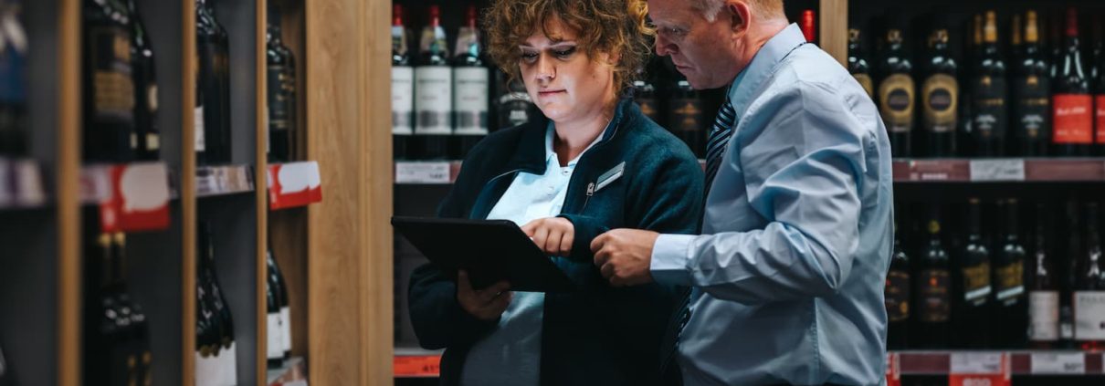 employees at wine store with ipad